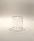 A transparent, cylindrical plastic container with a slightly flared top edge. Reminiscent of the My Store Crystal Clarity Teapot with its pristine appearance, the 600ml container is empty and placed on a neutral, light-colored surface with soft lighting creating subtle shadows.