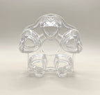 A clear, heart-shaped plastic ring, featuring five heart-shaped loops arranged in a circular pattern around a central opening, is reminiscent of the charm of the CozyGlow Tea Warmer by My Store. The object is set against a plain, light background.