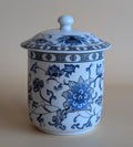 White ceramic jar with blue floral patterns on a beige background