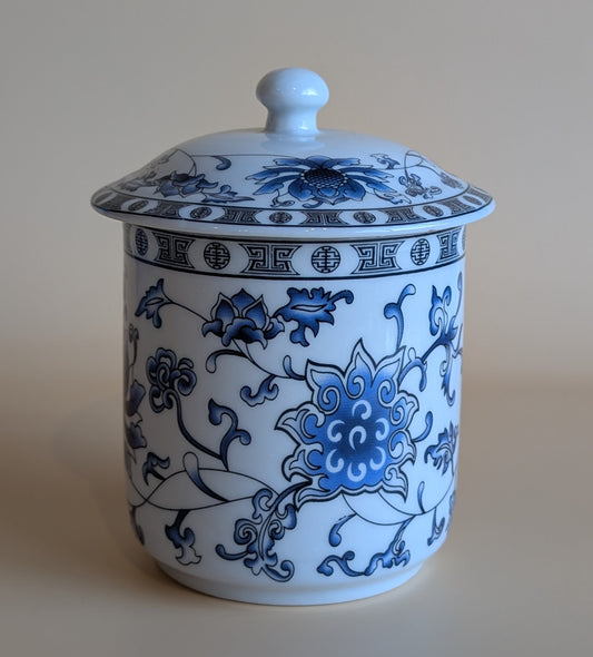 White ceramic jar with blue floral patterns on a beige background