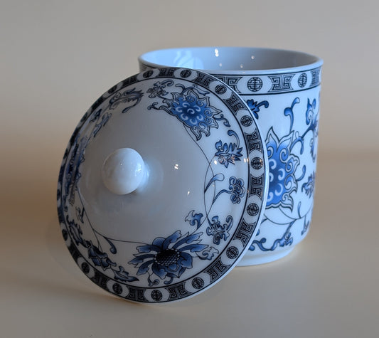 White ceramic jar with blue floral patterns on a beige background