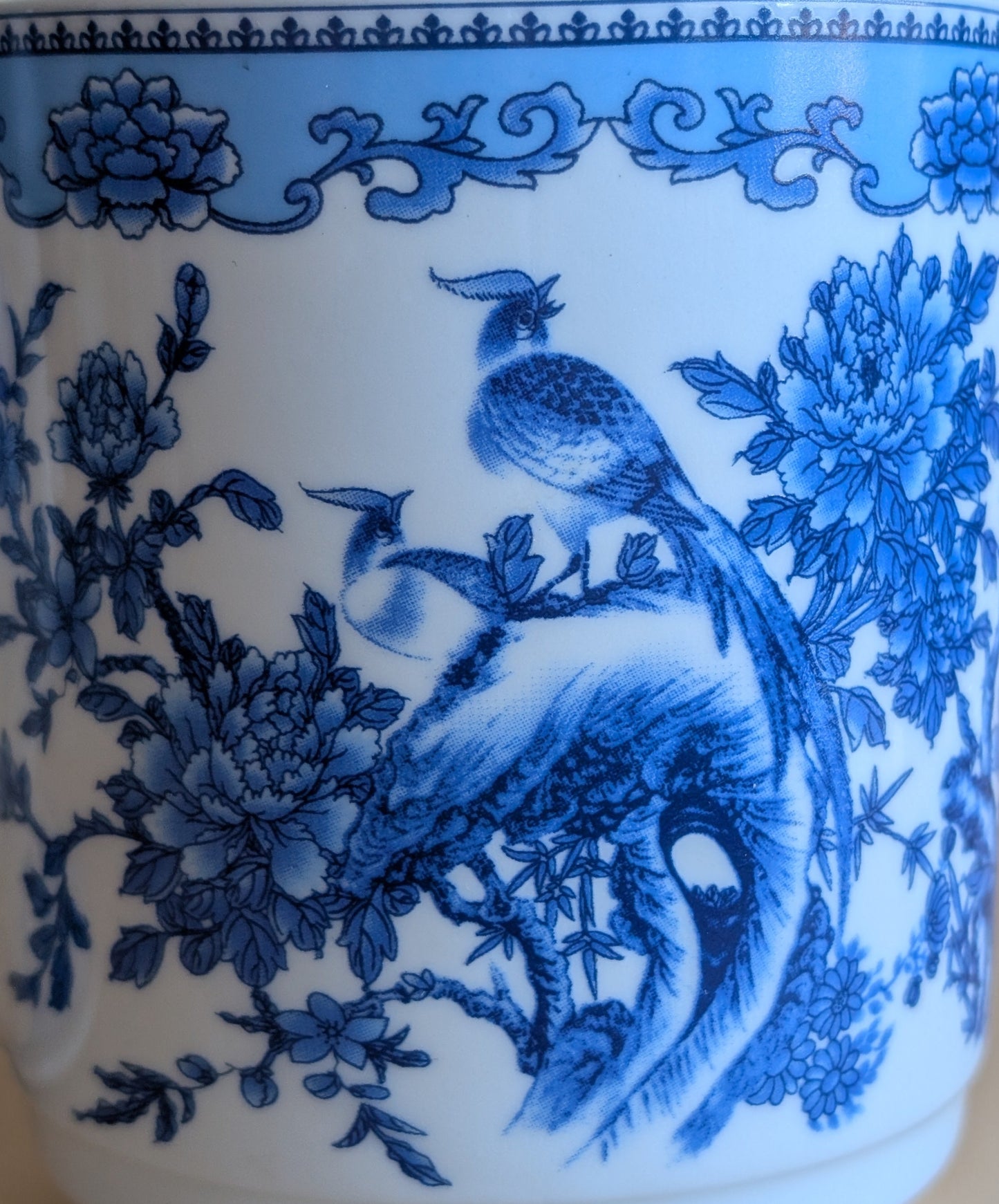 Blue floral and bird design on a white ceramic mug.