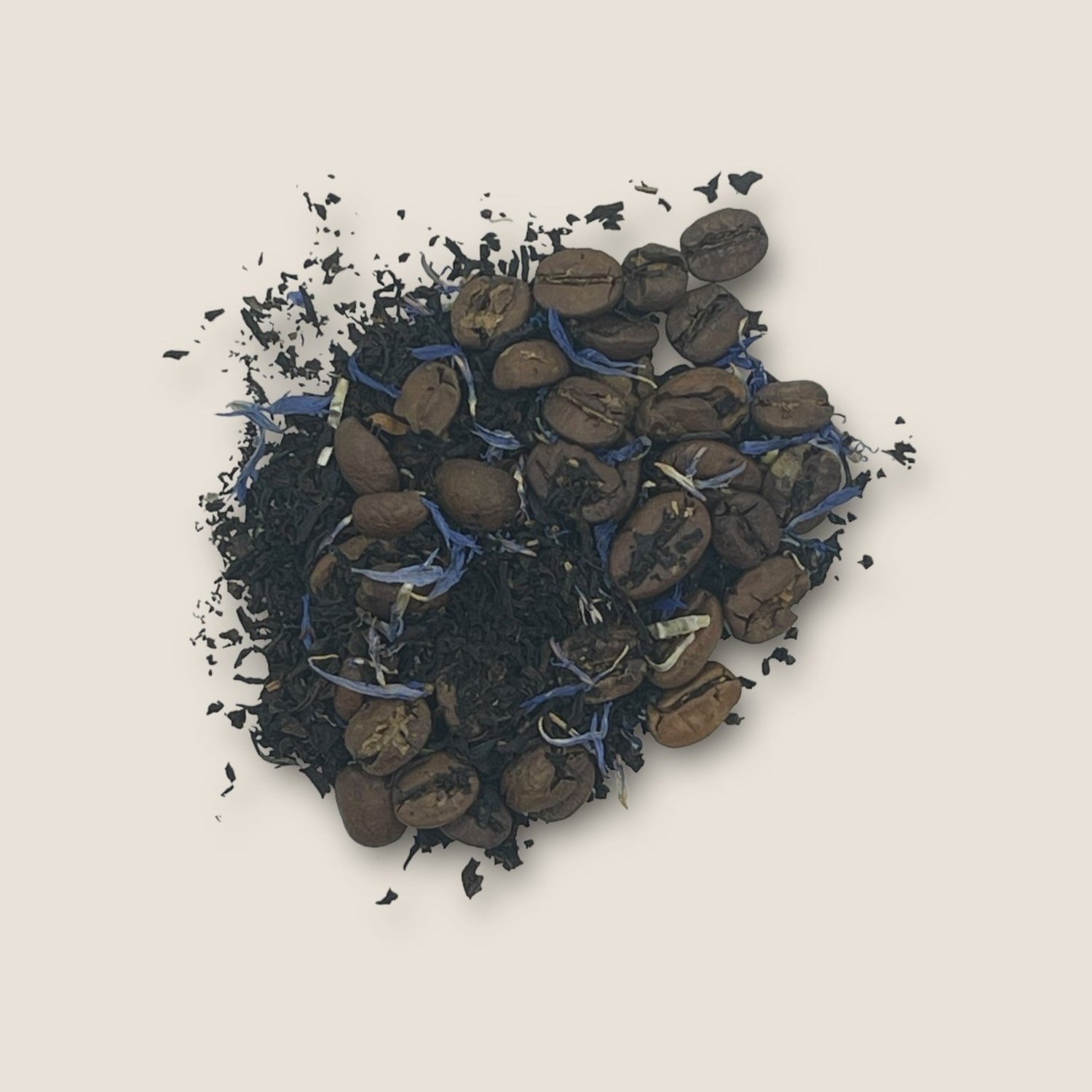 A visually textured blend of Espresso Martini by My Store features dark black tea leaves mixed with roasted coffee beans and small purple petals on a light beige background. The combination offers a striking contrast of deep colors and vibrant purple, promising an energy boost with each sip.