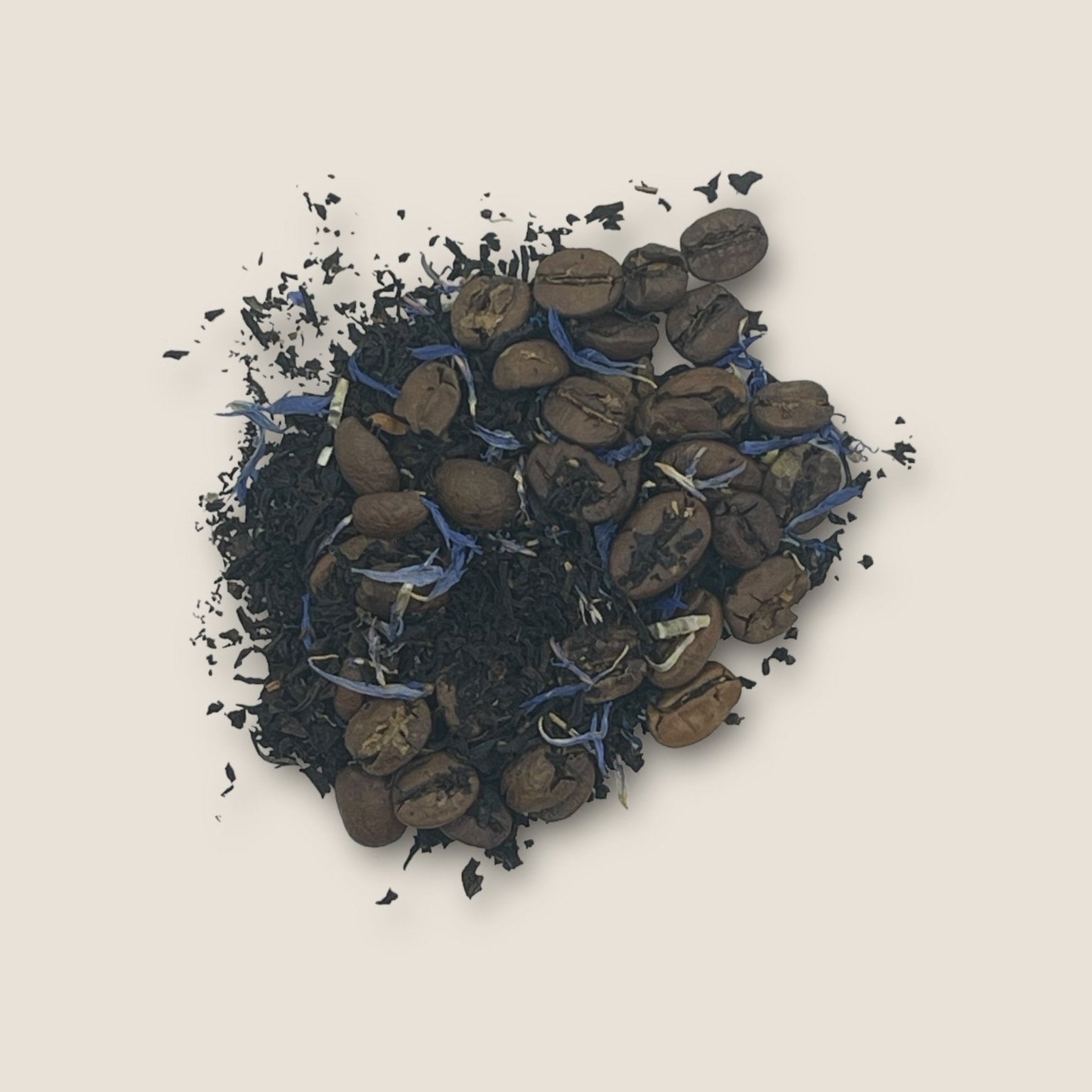 A visually textured blend of Espresso Martini by My Store features dark black tea leaves mixed with roasted coffee beans and small purple petals on a light beige background. The combination offers a striking contrast of deep colors and vibrant purple, promising an energy boost with each sip.