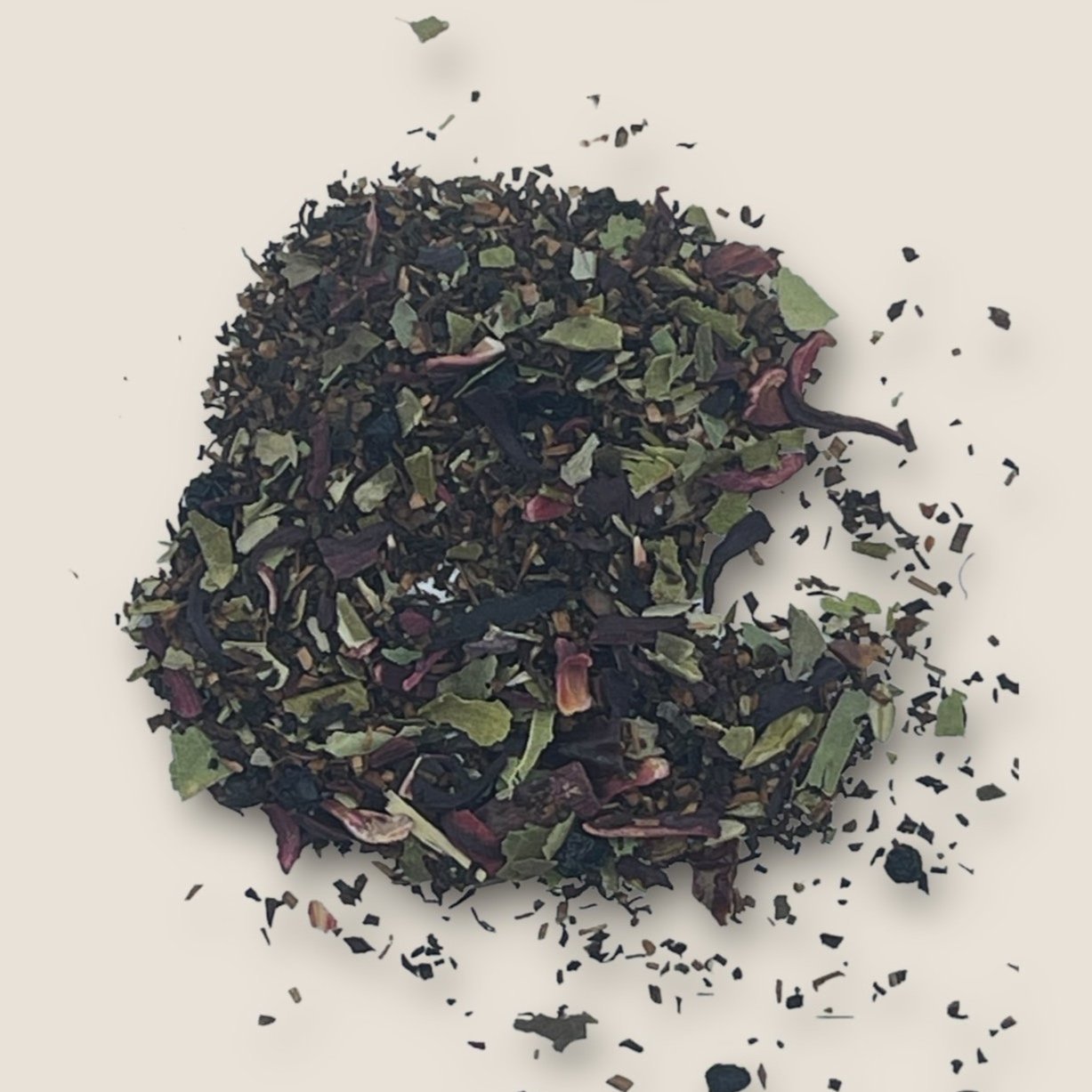 Fairy's Magic Tea by My Store showcases an array of loose tea leaves and herbs, boasting a colorful blend of dark, green, and purple pieces scattered across a light background. The freshly dried tea blend exhibits varied textures and hues, hinting at its diverse ingredients designed for detoxification and immune support.