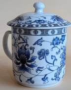 White ceramic mug with blue floral patterns on a beige background